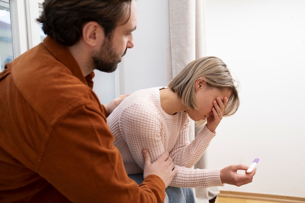 Primo piano coppia triste con test di gravidanza