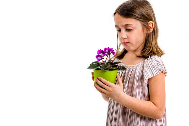 Photo close-up of sad girl with flower pot standing against white background