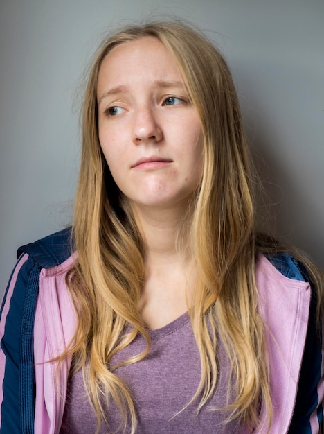 Photo close-up of sad woman against gray background