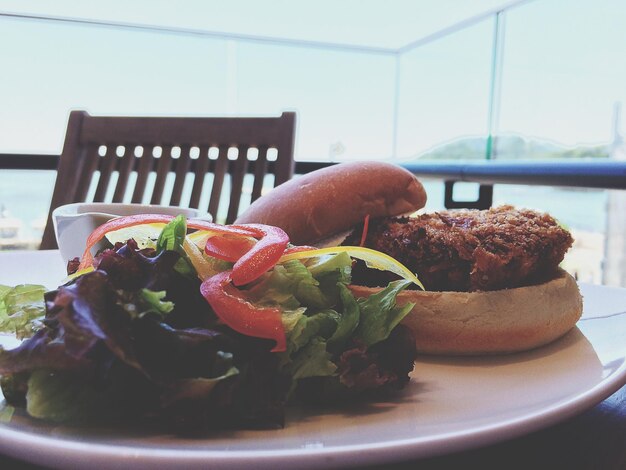 Close-up of salad and burger served on table in restaurant