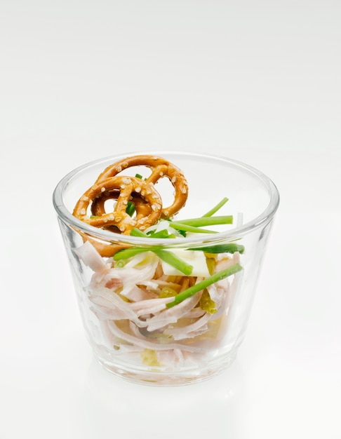 Close up on salad with salted pretzel in a glass