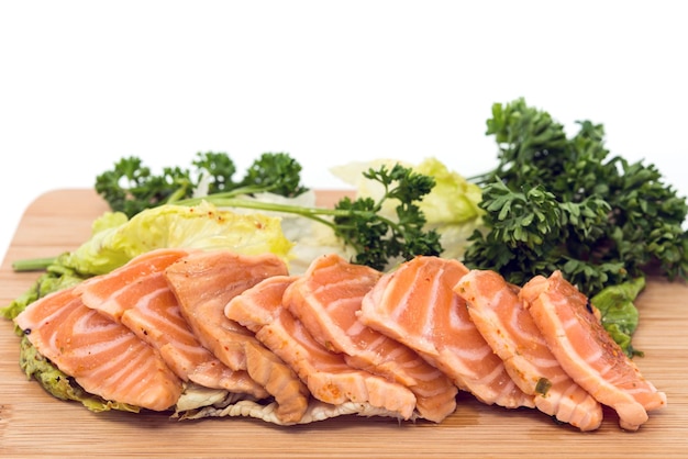 Foto close-up di sashimi di salmone su una tavola da taglio su uno sfondo bianco