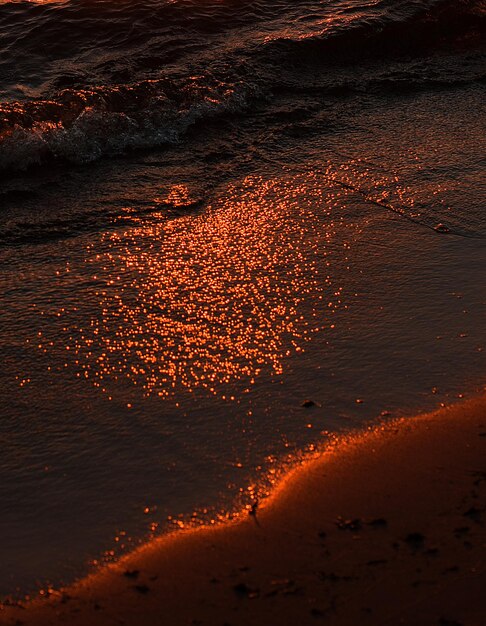 Close-up of sand sea shore during sunset