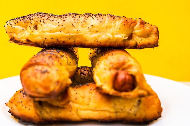 Close up of sausages baked in dough sprinkled with salt and poppy seeds sausages rolls delicious homemade pastries isolated