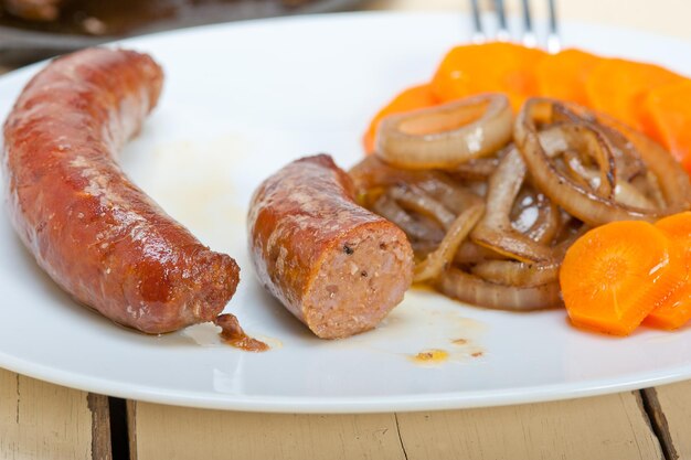 Photo close-up of sausages with roasted vegetables in plate
