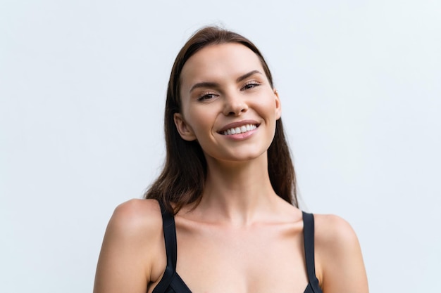 Close-up schoonheidsportret van een topless vrouw met perfecte huid en natuurlijke make-up op lichte witte muur achtergrond lachen en glimlachen met sneeuwwitte perfecte tanden