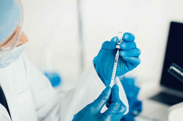 Close up. scientist filling a syringe with a new vaccine. photo with a copy-space.