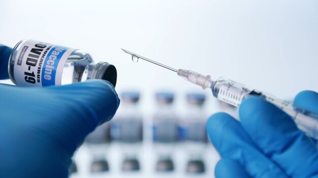 Close up, Scientist is holding a glass vial for Covid-19 vaccine and syringe in laboratory