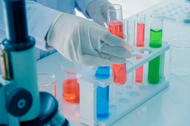 Photo close-up of scientist performing scientific experiment in laboratory glassware