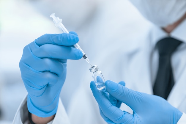 Close up. scientist in protective gloves is testing a new vaccine . photo with copy - space.