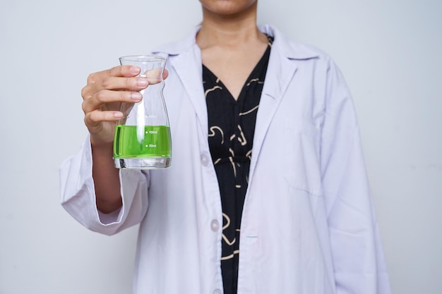 Close-up of scientist in a white lab coat with chemical glassware.