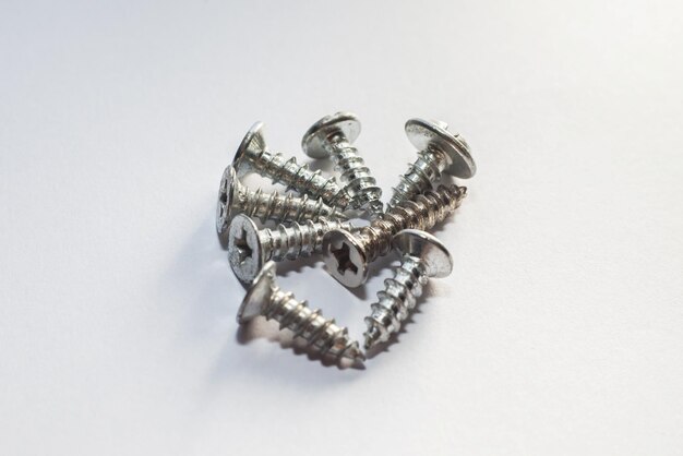 Photo close up of screws on white background