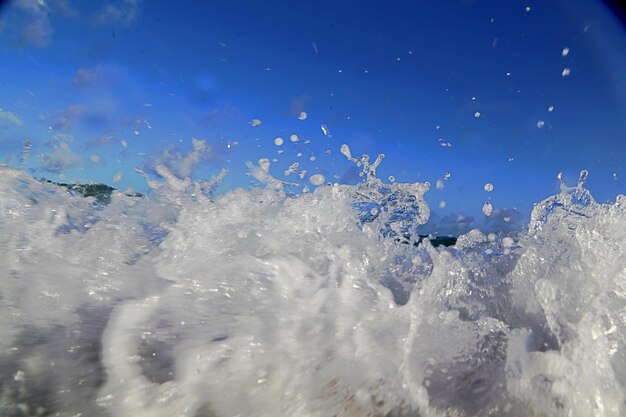 Close-up of sea waves against blue sky