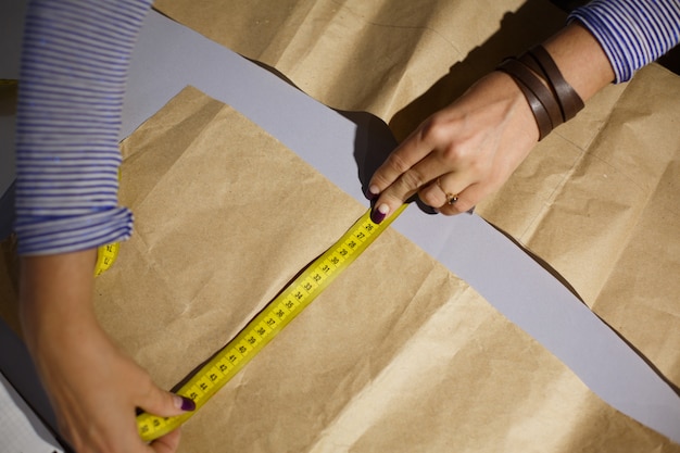 close up of a seamstress's hand with a centimeter