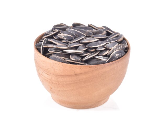 Photo close-up of seeds in wooden bowl against white background