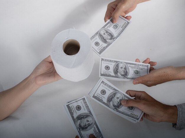Close-up sellbuy tissue hand houdt toiletpapier tissue en geld van 100 US dollar bankbiljet