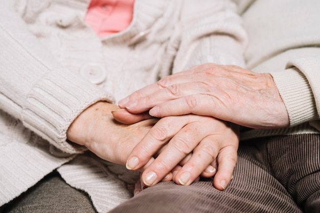 Close up of senior couple holding hands