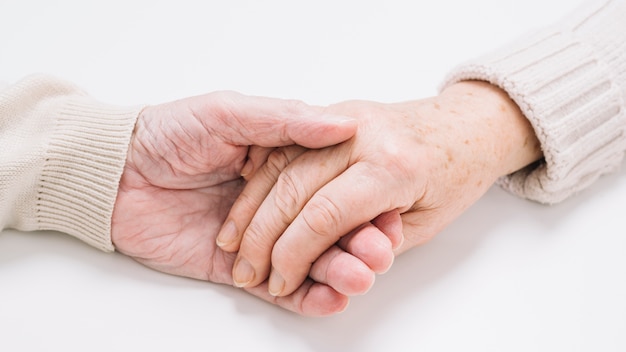 Close up of senior couple holding hands