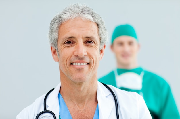 Close up of a senior Doctor standing in front of his team