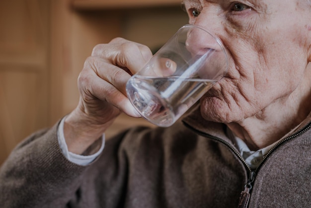 水を飲む年配の男性のクローズアップ