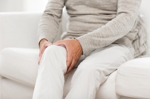 Photo close up of senior man suffering from knee ache