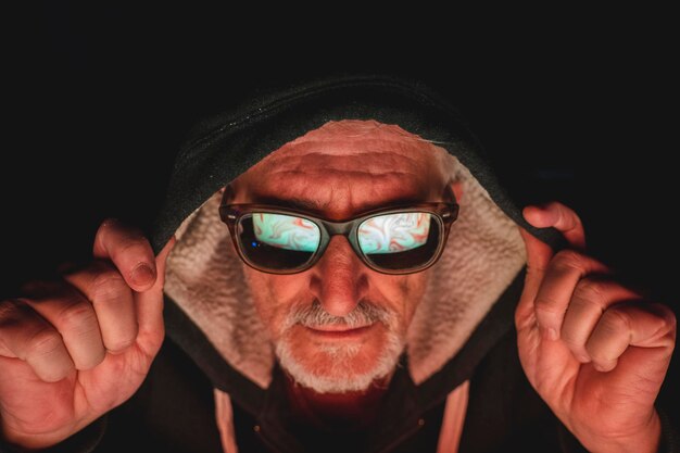 Photo close-up of senior man wearing sunglasses against black background