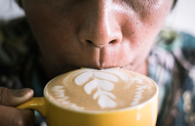 Foto chiuda in su del caffè bevente della donna maggiore