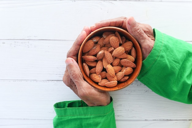 close up senior women hand holding a bowl on almond