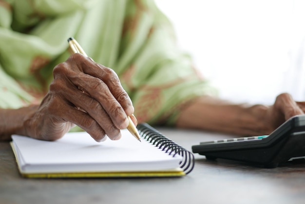 Close up of senior women hand writing on notepad