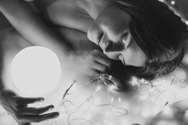 Close up sensual woman with illuminated sphere monochrome portrait picture