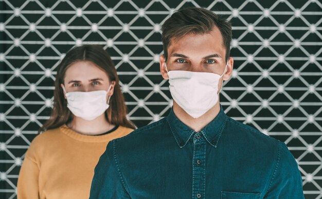 Close-up serieuze man en vrouw met beschermende maskers