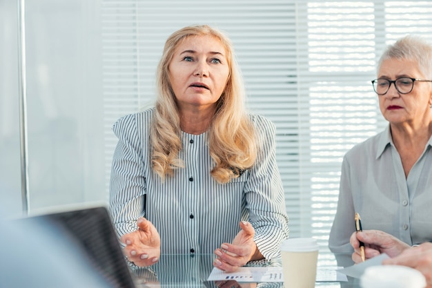 Close up. serious business woman explaining something to her colleagues