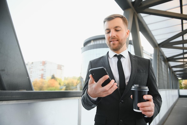 Close up serious businessman drinking take away coffee at\
street portrait of business man waiting with coffee to go outdoor\
office employee looking away at street male professional take\
break