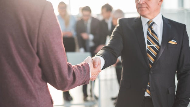 Close up serious businessman meeting his business partner with a handshake