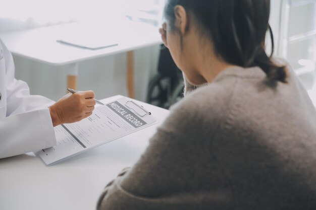 노인 세대 건강 관리에 대한 권장 사항을 제공하는 치료를 설명하는 사무실 의사 약속에서 성숙한 여성 환자와 상담하는 의료용 안면 마스크를 착용한 진지한 의사를 닫습니다.