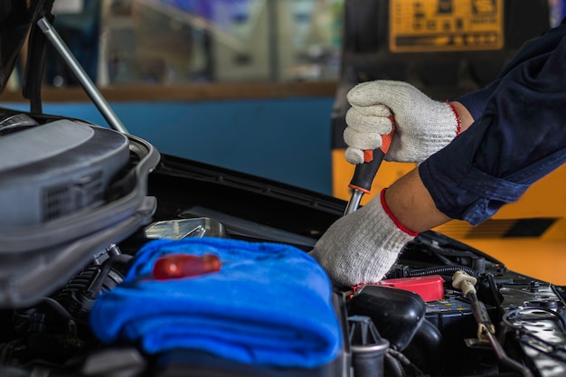 Close up, Service is People are repair a car Use a wrench and a screwdriver to work in garage.