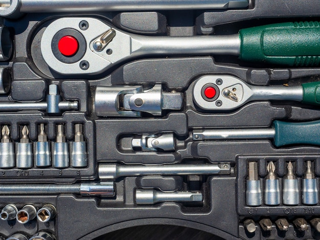 A close-up of a set of tools for repairing a car and other things. wrenches, bits, attachments. Top view, flat lay