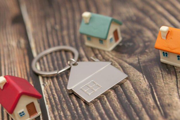 Photo close-up several colored houses and a key chain on a wooden background