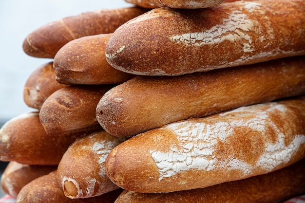 Close up several fresh French baguette bread buns on retail display of bakery store, high angle view