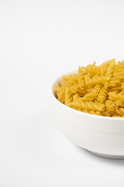 Close up of several types of dry pasta in a plate on white background