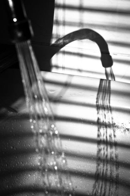 Photo close-up of shadow of water beam out of water tap