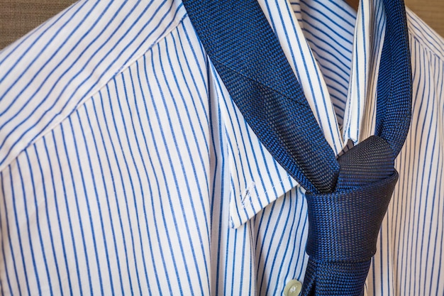 Photo close-up of shirt and necktie hanging on coathanger