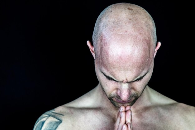 Foto close-up di un uomo senza camicia su uno sfondo nero