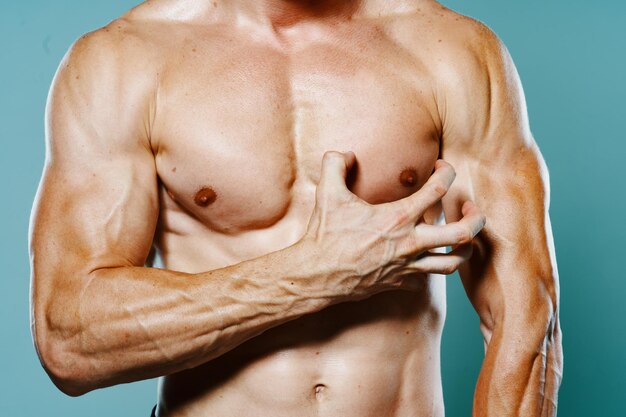 Foto close-up di un uomo senza camicia su uno sfondo grigio