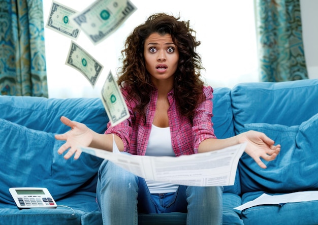 Photo close up of shocked woman sitting at the table stressed and confused by calculate expense from invoice or bills have no money to pay mortgage or loan high prices and spending money concept