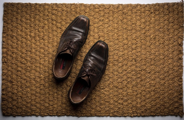 Photo close-up of shoes on doormat