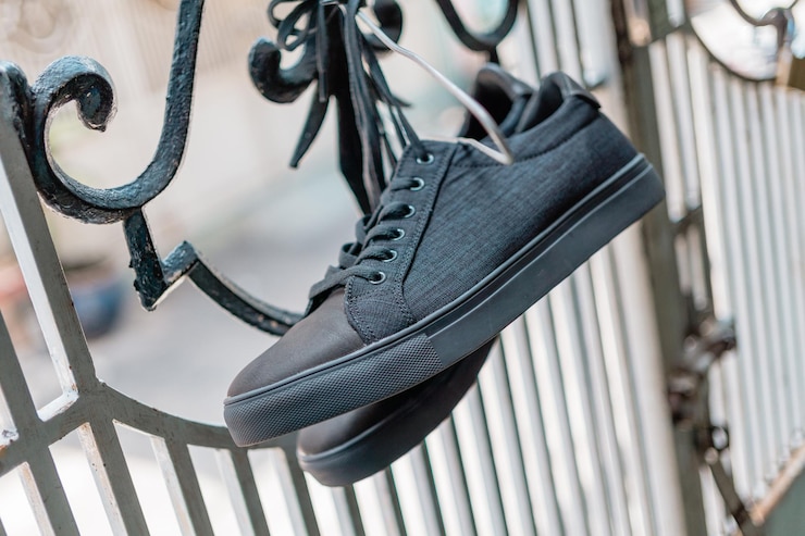Photo close-up of shoes hanging on metal