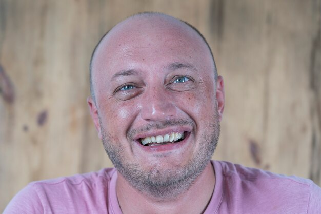 Close-up shoot van een blanke kale man van middelbare leeftijd die recht naar de camera kijkt. Mensen en levensstijl concept. Portret van een man van middelbare leeftijd binnenshuis