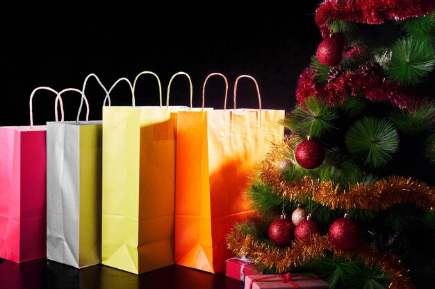 Photo close-up of shopping bags and christmas decorations over black background