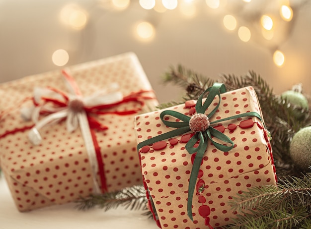 close up shot of beautifully wrapped christmas gifts on blurred background of blurry lights.